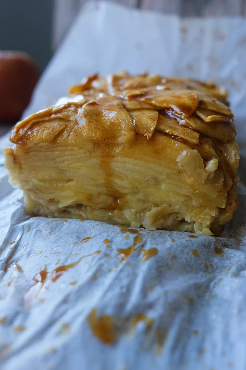 Cut invisible apple cake showing layers of thinly sliced apples and soft cake.