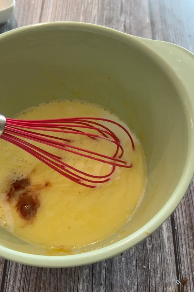 Melted butter, milk, and vanilla added to the egg mixture for invisible apple cake.