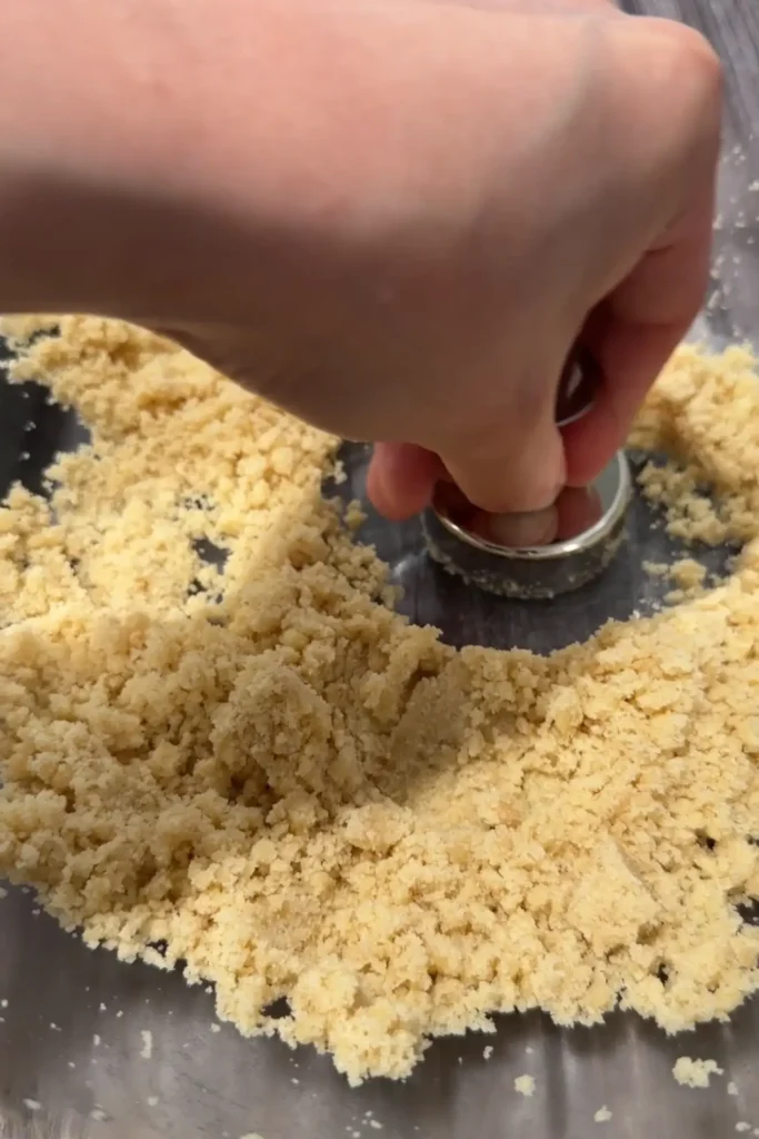 Polvoron mixture being packed into a round polvoron mold.