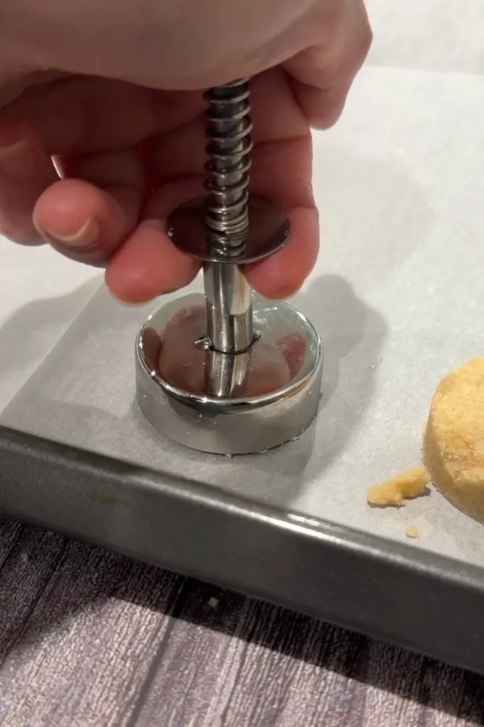 Polvoron mold pressed onto a parchment-lined baking sheet.