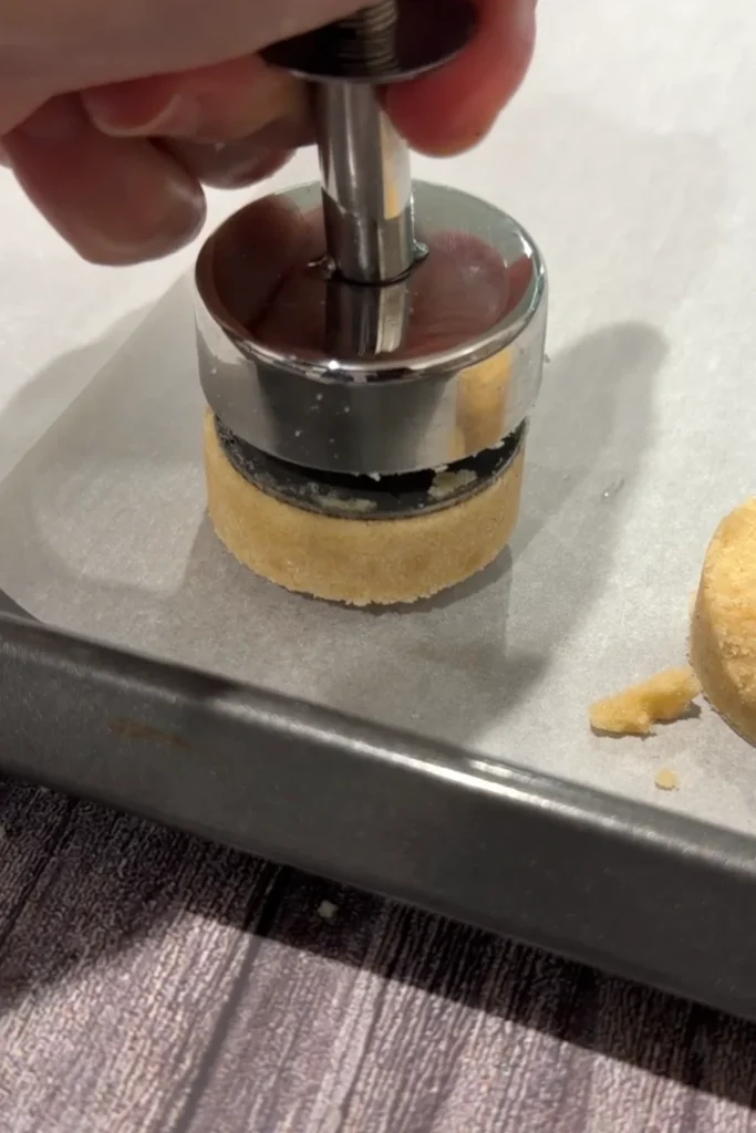 Polvoron being released from the mold onto parchment paper.