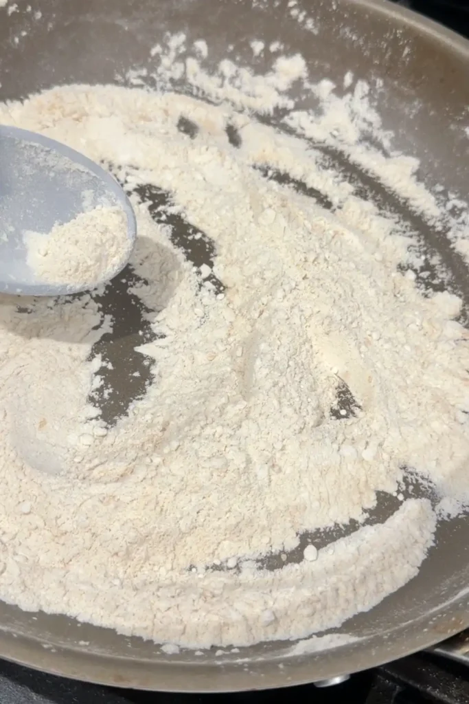 Toasted flour being stirred in a skillet for polvoron.