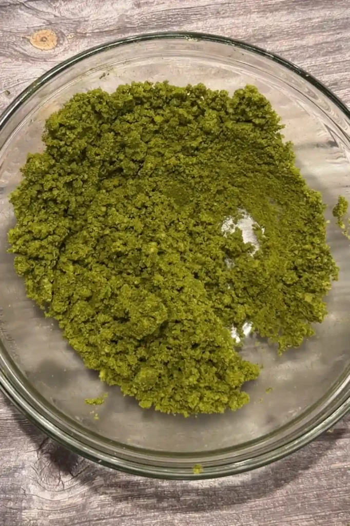 Green matcha polvoron mixture combined in a glass bowl.