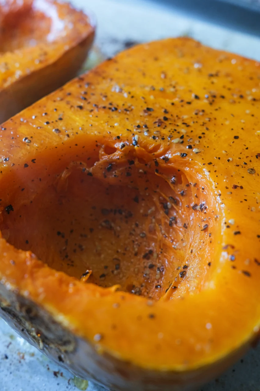 Close-up of oven roasted butternut squash seasoned with salt and freshly ground black pepper.
