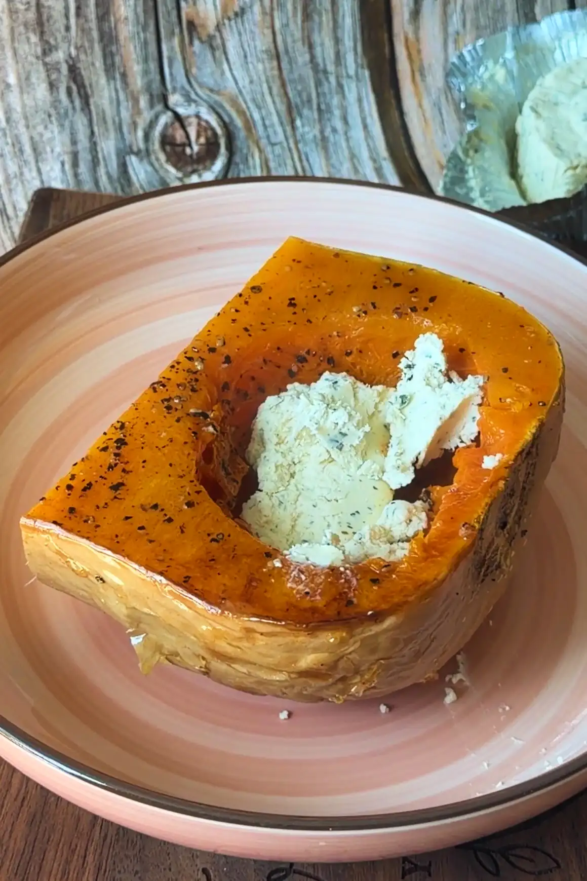 Roasted butternut squash half served with Boursin cheese ready to be mashed together.