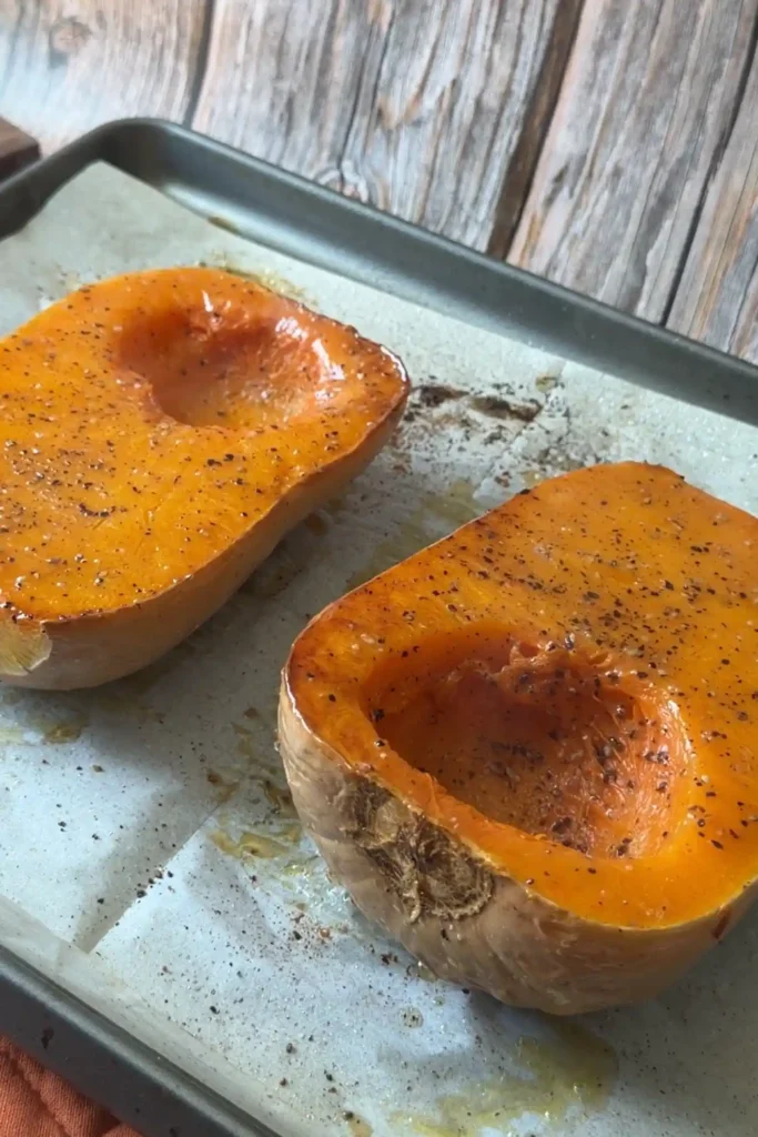 Easy oven roasted butternut squash seasoned with salt and black pepper on a baking sheet.