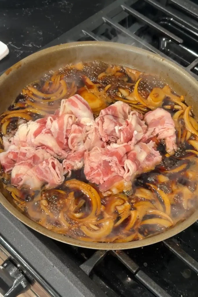 Thinly sliced raw beef added to the simmering broth and onions.