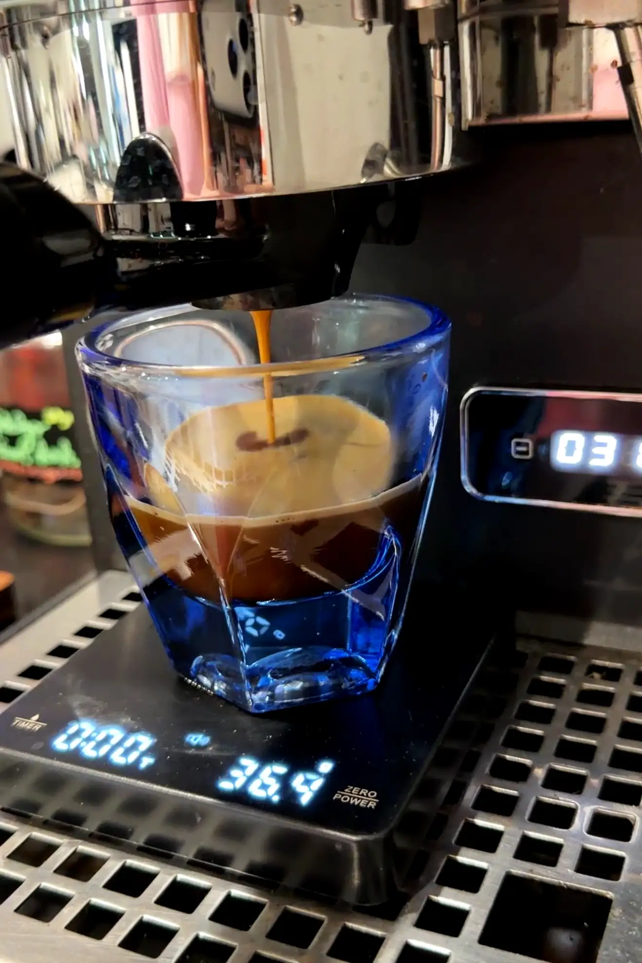 Two shots of fresh espresso being pulled from an espresso machine for an iced pumpkin spice latte.
