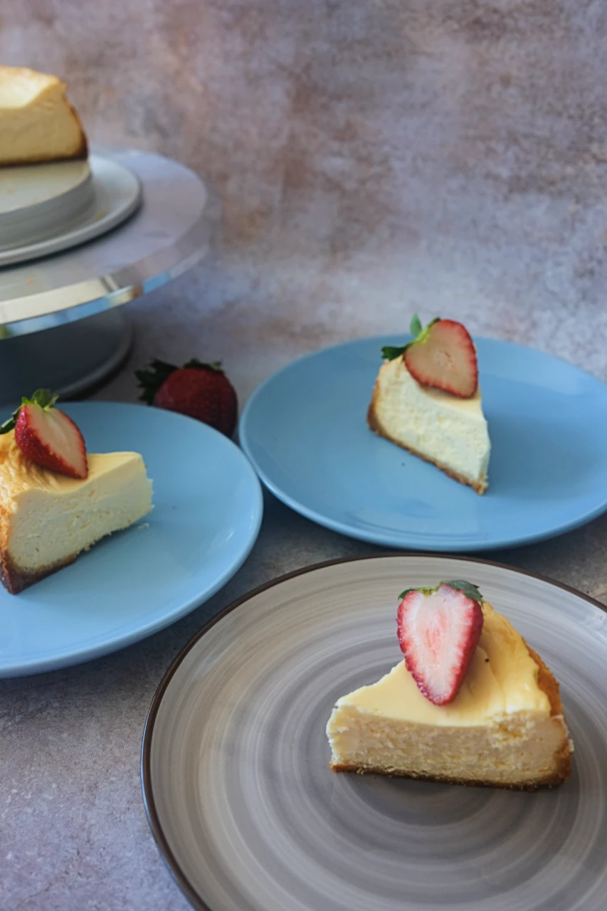 Slices of keto cheesecake topped with strawberry slices on plates