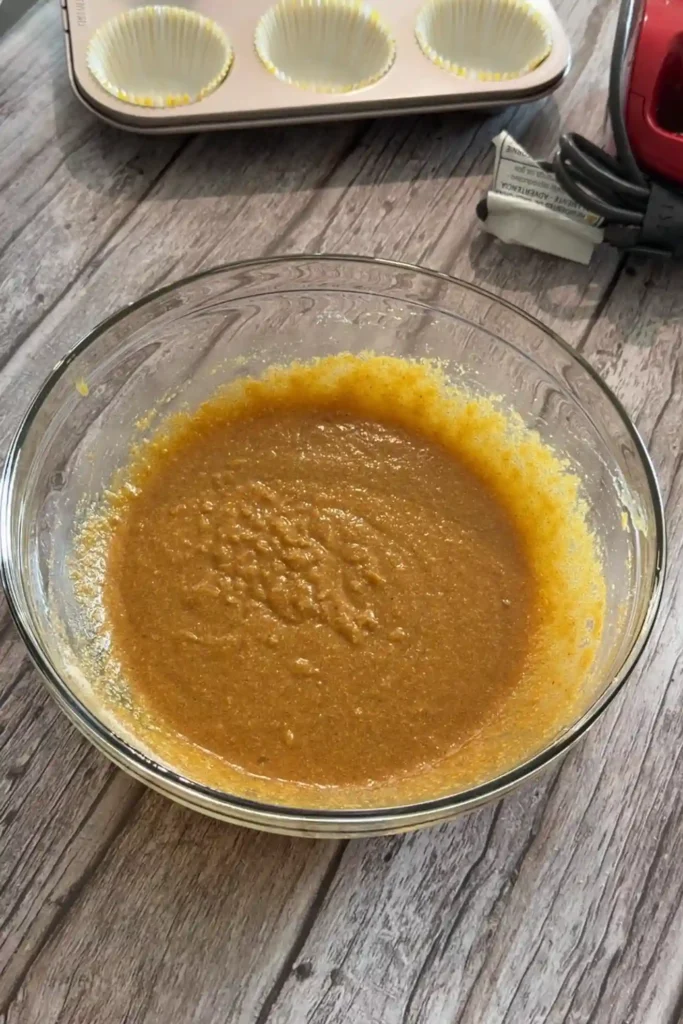 Combined keto pumpkin muffin batter in a glass mixing bowl.