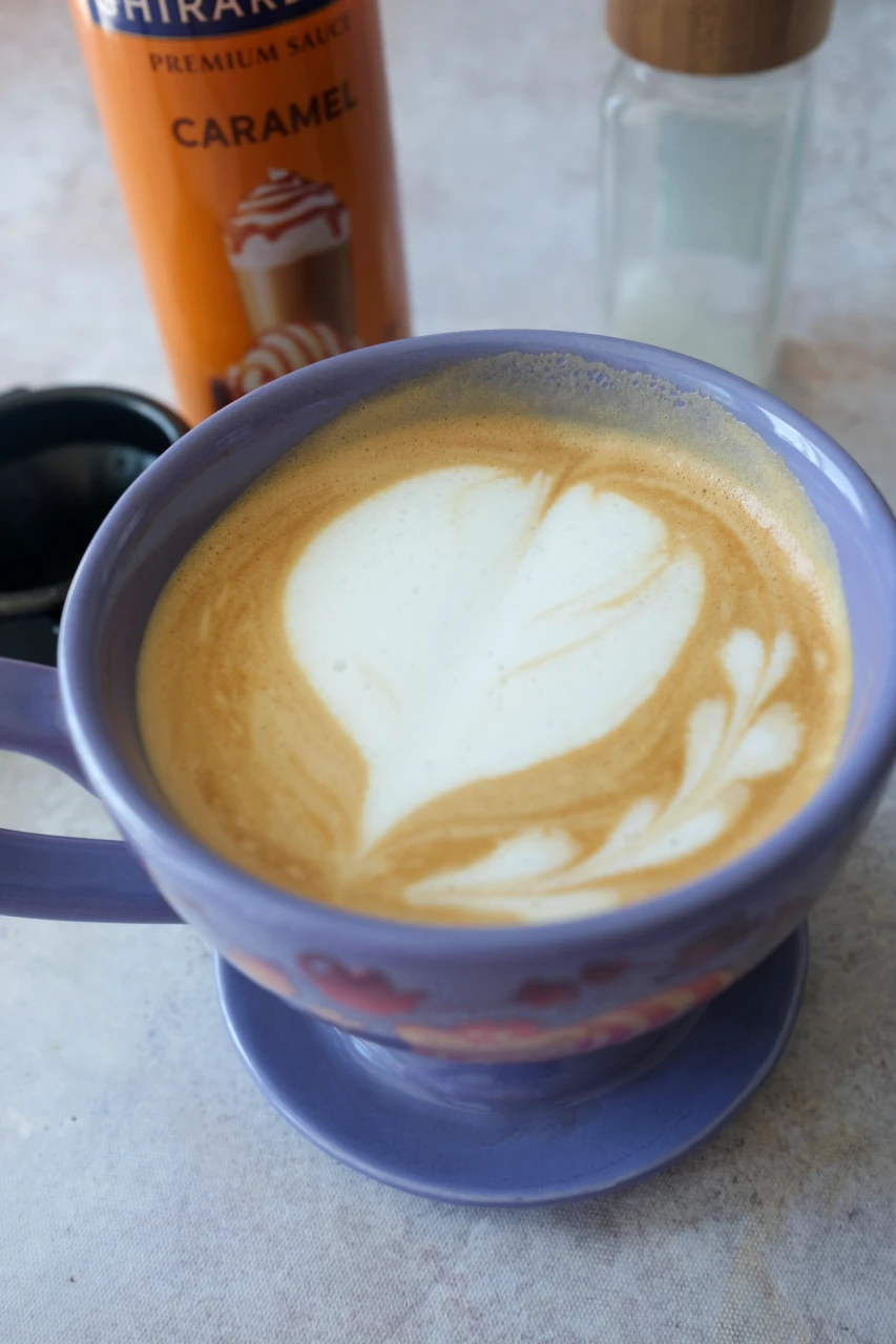 Homemade salted caramel latte with a large heart design made from steamed milk foam.
