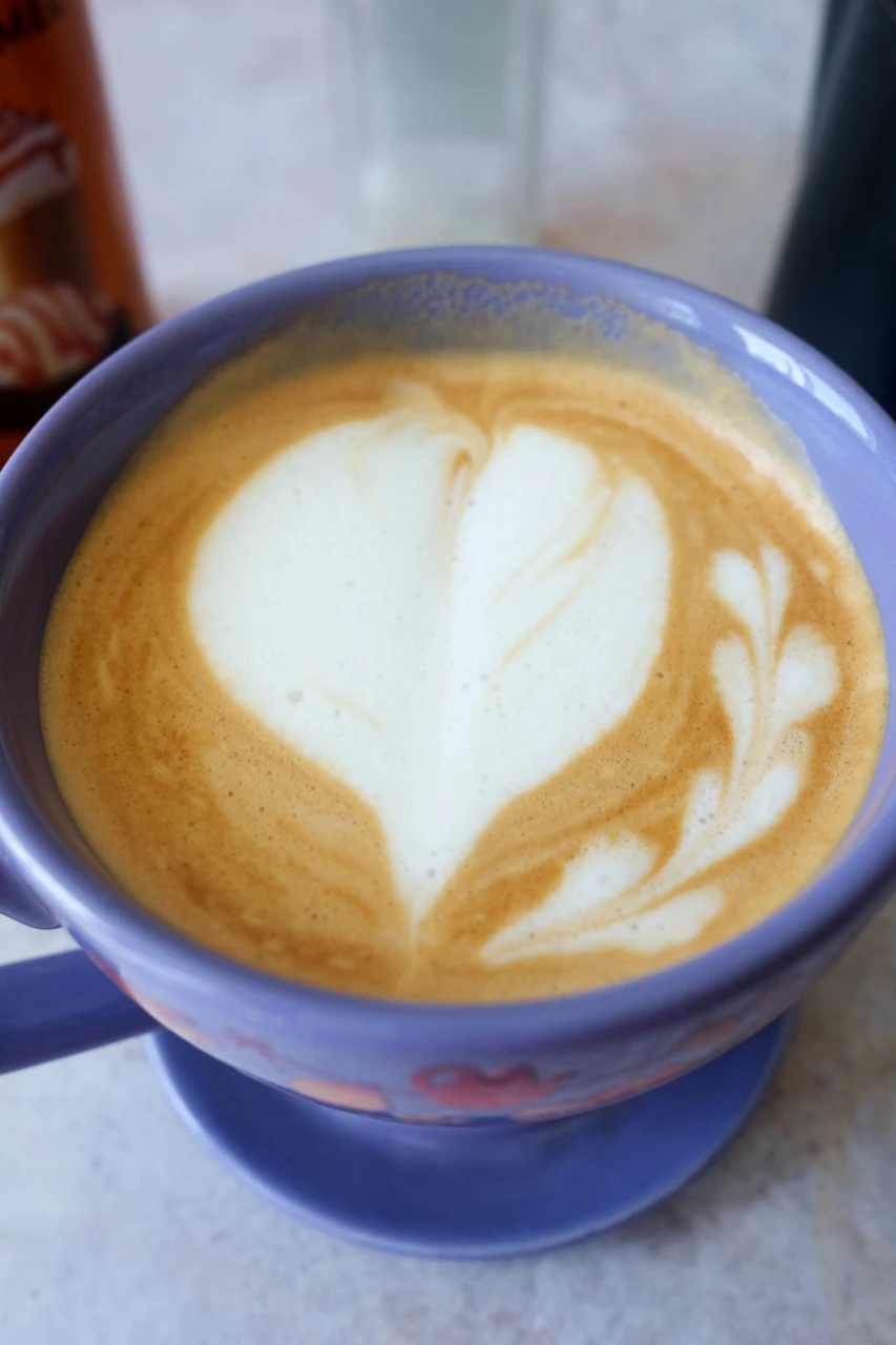 Homemade salted caramel latte with a large heart design made from steamed milk foam.