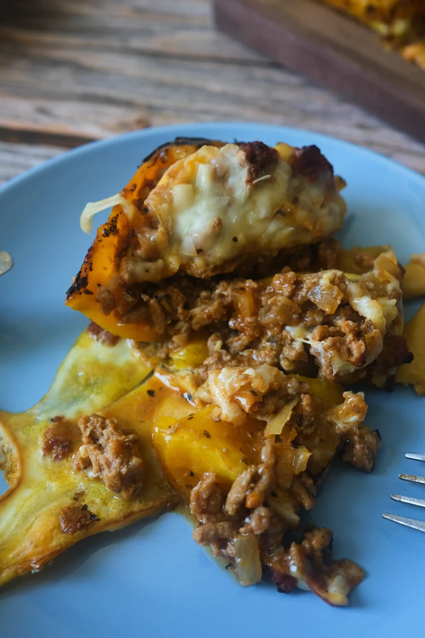 Cut-open stuffed bell pepper showing seasoned ground turkey, egg, and melted cheese filling.